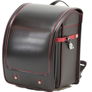岐阜横山鞄のランドセルです。品番h2bkr-cの斜め前側です。黒×赤色の牛革と人工皮革のハイブリッドで手作りされ、ランドセルです。
