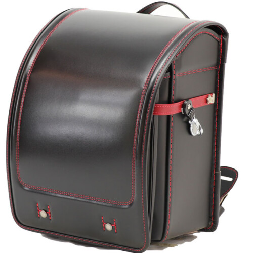 岐阜横山鞄のランドセルです。品番h2bkr-cの斜め前側です。黒×赤色の牛革と人工皮革のハイブリッドで手作りされ、ランドセルです。
